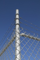 Photo of fence with barbed wire to signify a prison